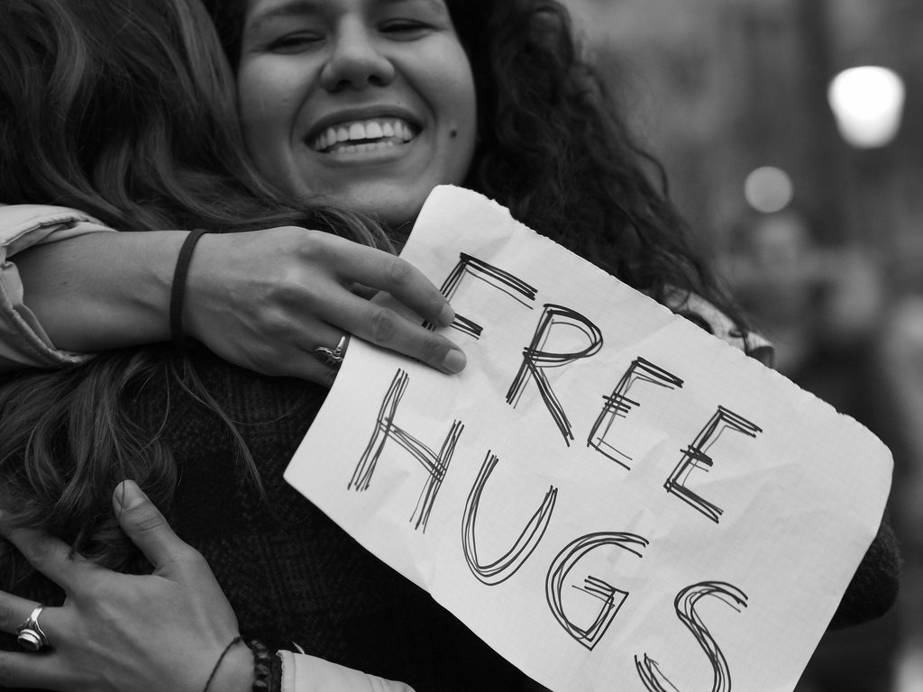 woman free hugs sign black white