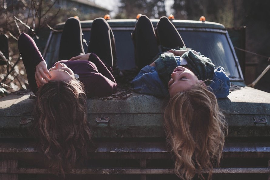 Two friends on the hood of a car