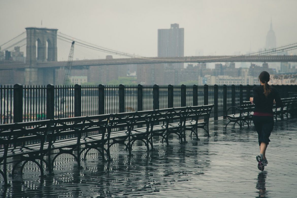 woman jogging rain new york nyc bridge