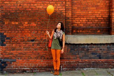 woman brick wall balloon