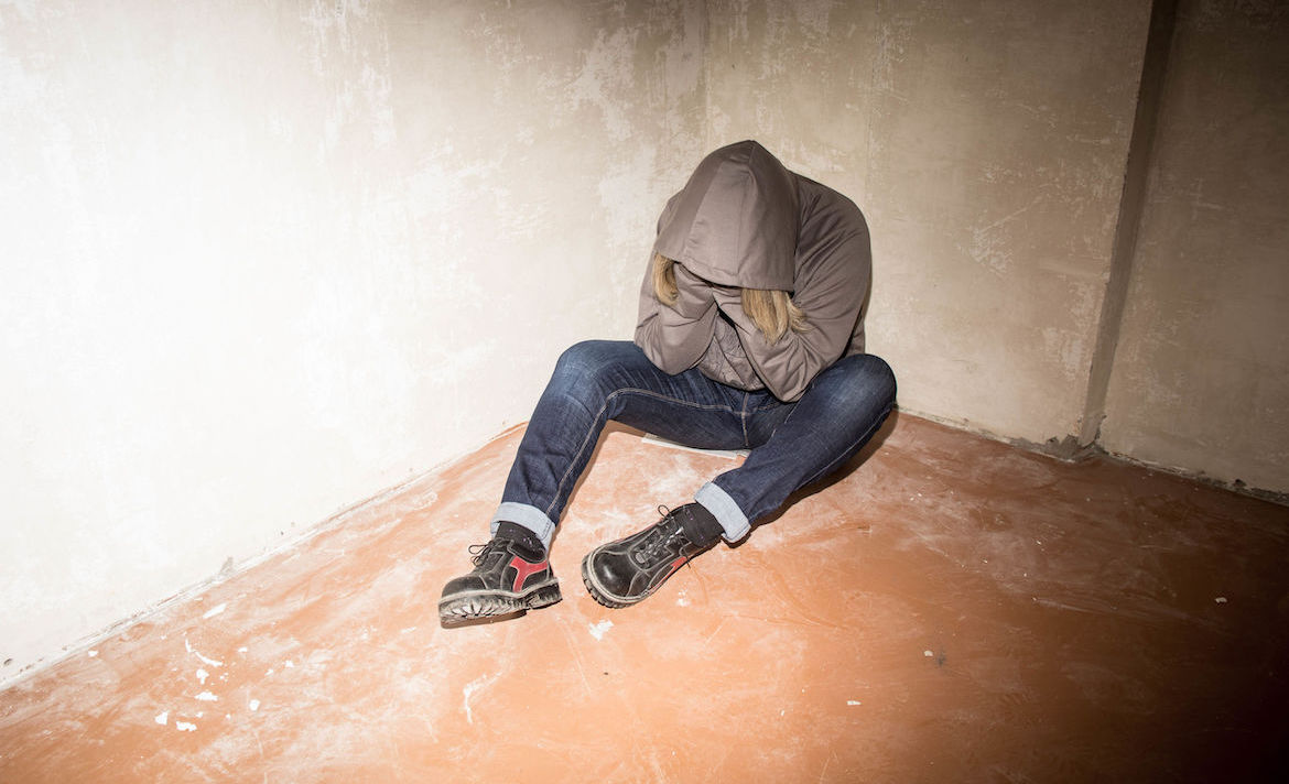Portrait of man sad, drug addict man sitting on the floor in corner